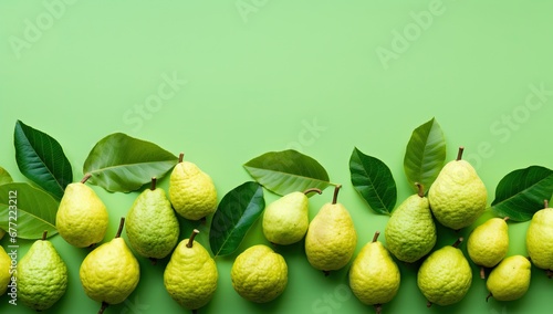 Ripe guava fruits with green leaves on a green background.