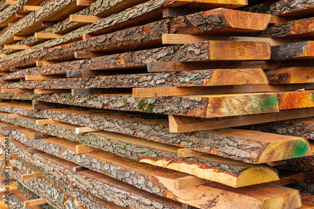 Wooden timber at a sawmill. Boards with bark