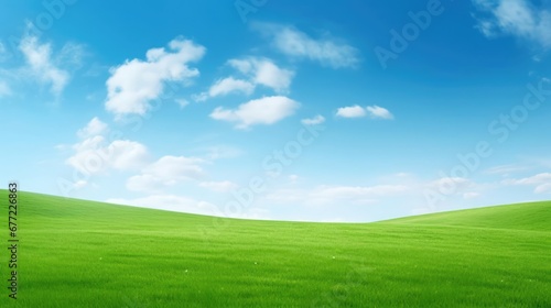 Lush green grass under bright blue sky with clouds  © Charlie