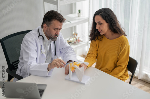 Male doctor talking to woman about illness in clinic. Caucasian doctor to check up health female in examination hospital room. Healthcare and medical concept.