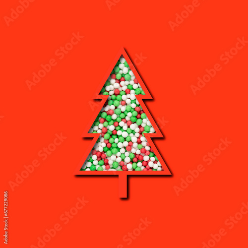 christmas tree shape with colorful sprinkles isolated on red background, paper cutout