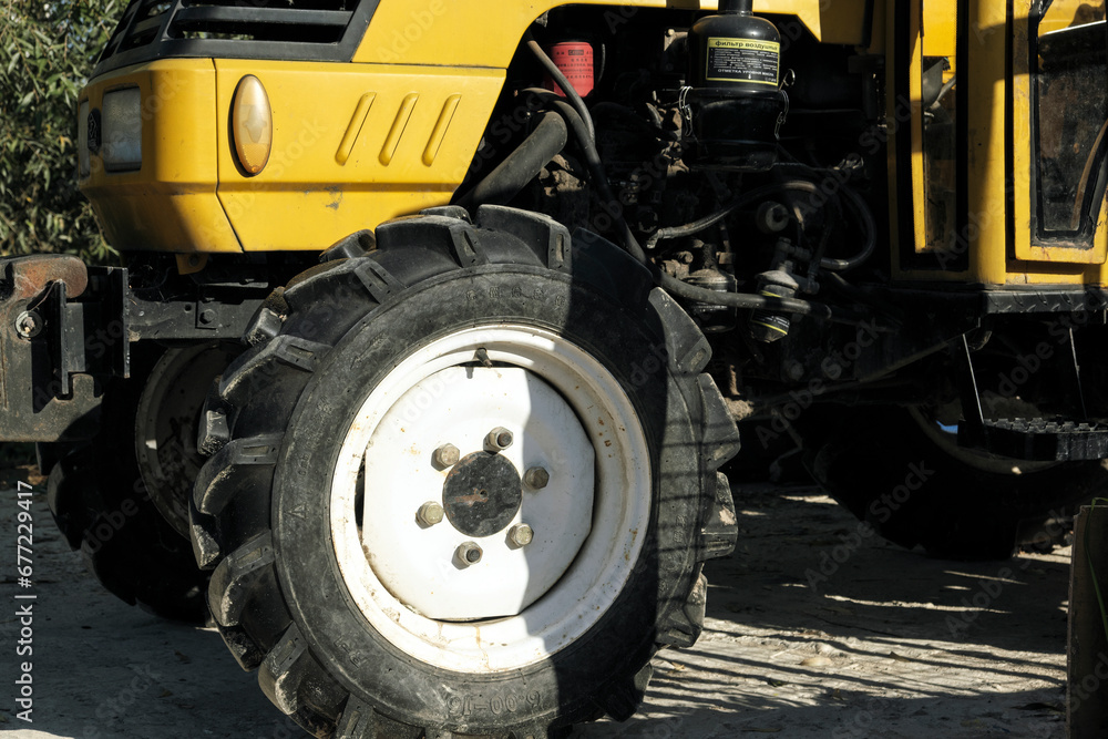 A yellow tractor stands in a field on a farm. A yellow tractor stands in a field on a farm.