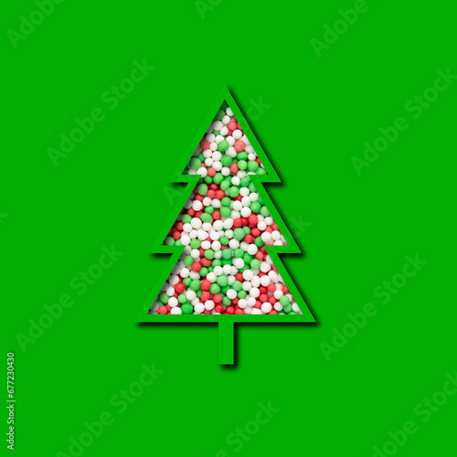 christmas tree cutout with colorful sugar sprinkles isolated on green background, christmas bakery and pastry,