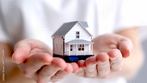 a model of a house in the hands of a realtor's girlfriend