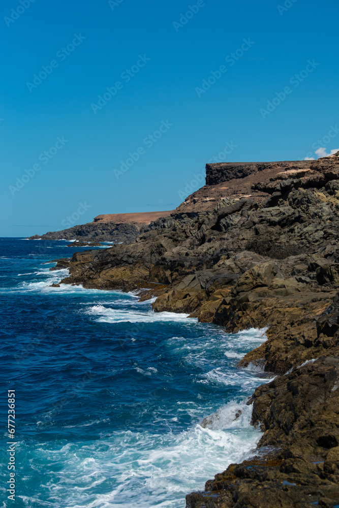 Beautiful landscape with deep blue water. Powerful waves crash against black volcanic rocks on the coast of ´Aguas Verdes, Fuerteventura island. 