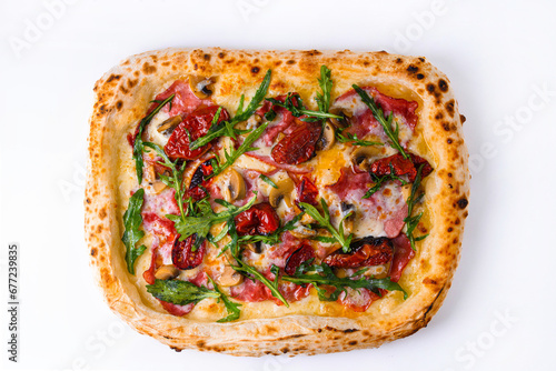 pizza with smoked beef, dried tomatoes, mushrooms and arugula on a white background