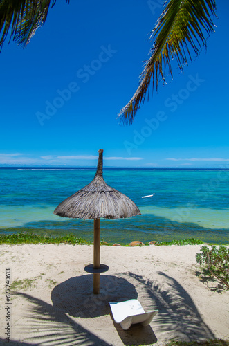 Beautiful landscape - Sun-protection umbrella on tropical Belle Mare beach in Mauritius Island, Indian Ocean. Summer vacation and tropical beach concept.