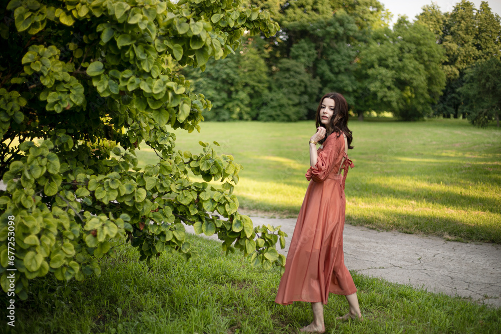 Portrait of a gorgeous brunette girl in dress posing in the park, tree background.
Portrait of a gorgeous brunette girl in dress posing in the park, tree background.