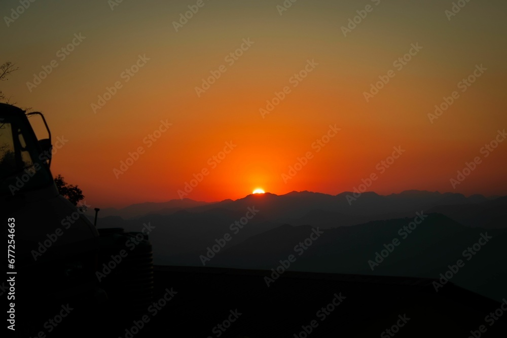 Mesmerizing Sunset view from silhouette Rupakot Resort, Nepal with orange sky