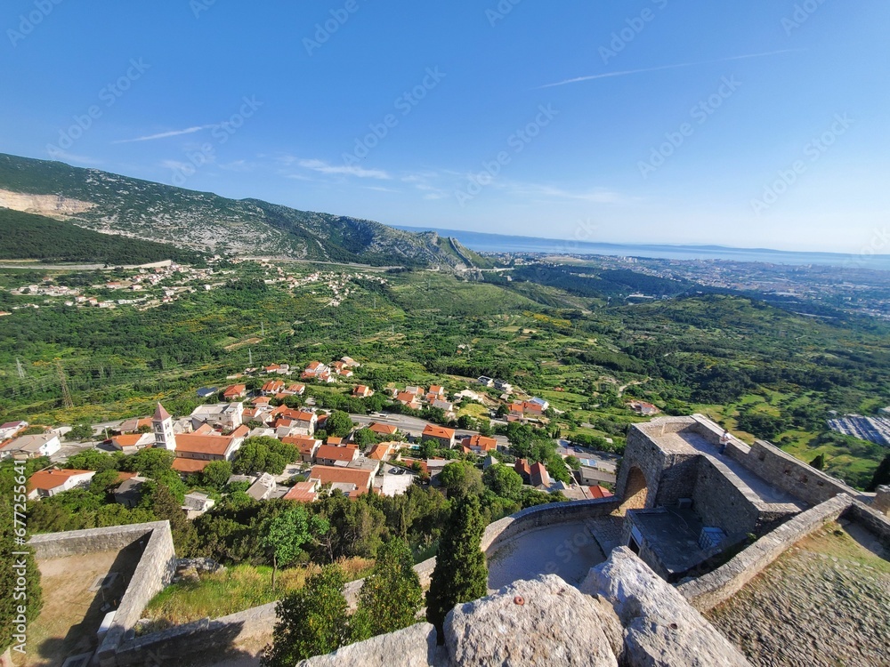 Landscape of fields covered in greenery from the Klis Fortress in Croatia
