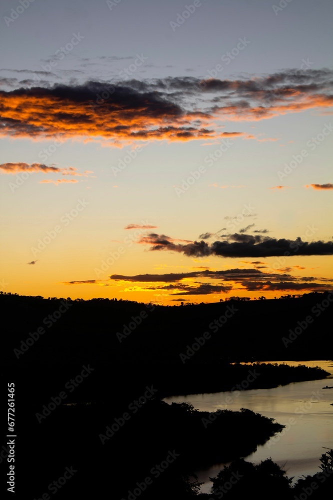 Silhouette of hills and a river during the sunset