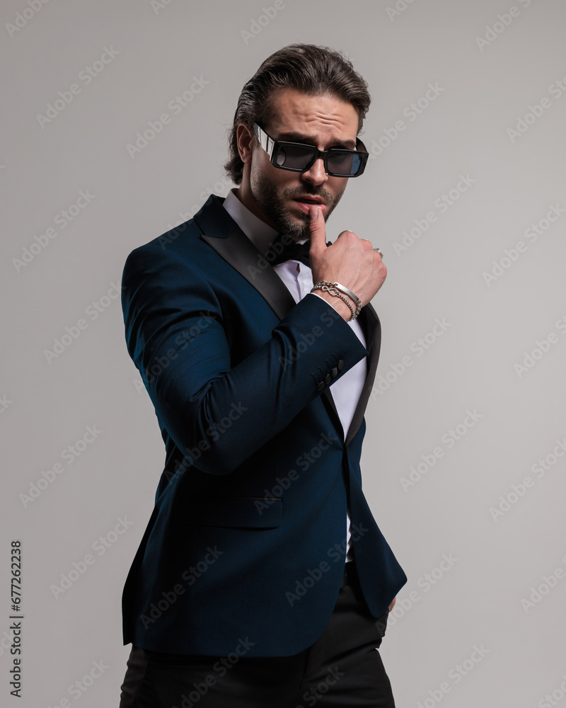 Fototapeta premium seductive elegant man with sunglasses sensually touching lips