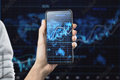 Smartphone displaying financial data graphs in hand