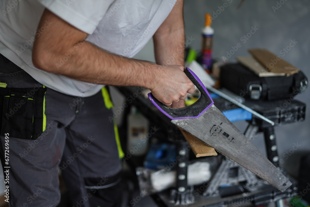 A man sawing a piece of wood A man sawing a piece of wood