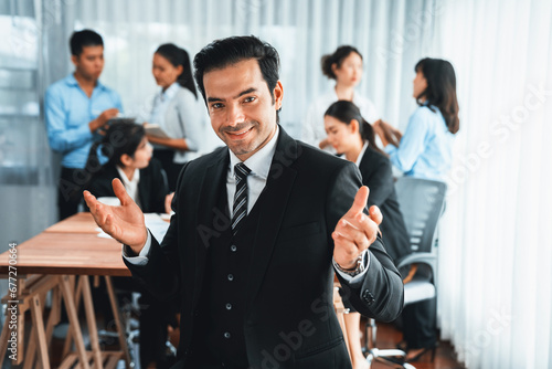 Portrait of happy businessman looking at camera with motion blur background of business people movement in dynamic business meeting. Habiliment