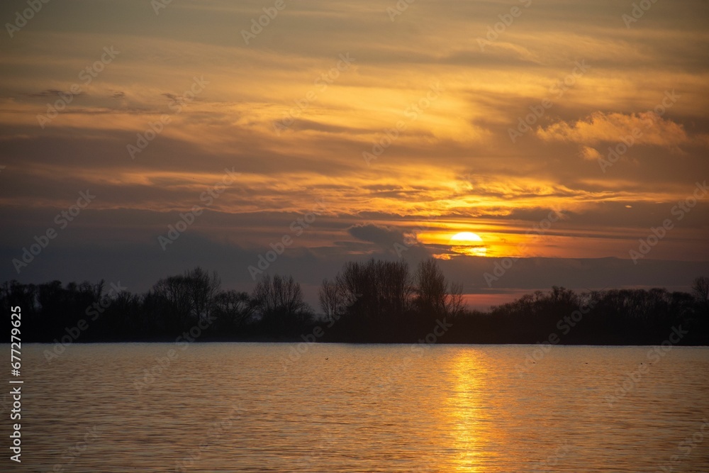 Mesmerizing sunset view in a horizon of lake with silhouette of trees