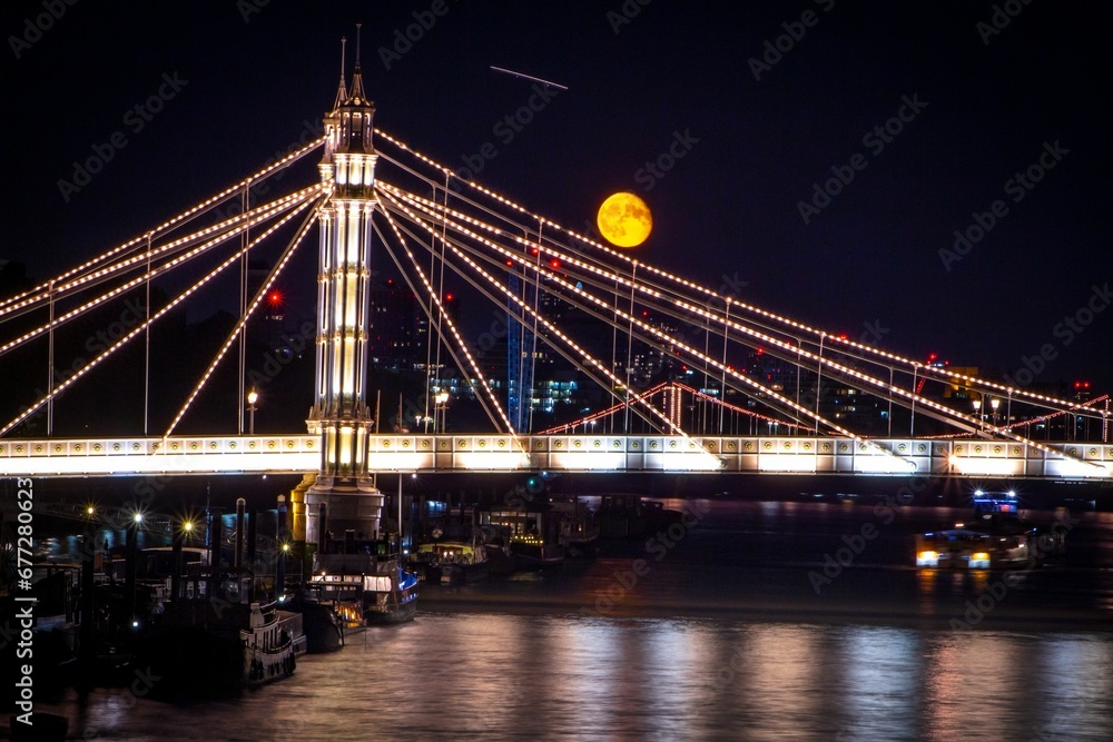 Beautiful shot of an illuminated bridge under the golden moon in London