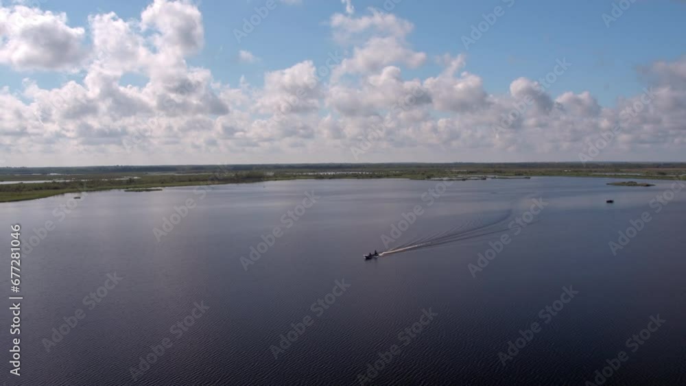 Aerial Panning Scenic Shot Of Motorboat Moving In River Against Cloudy Sky - Bayou, Louisiana Aerial Panning Scenic Shot Of Motorboat Moving In River Against Cloudy Sky - Bayou, Louisiana