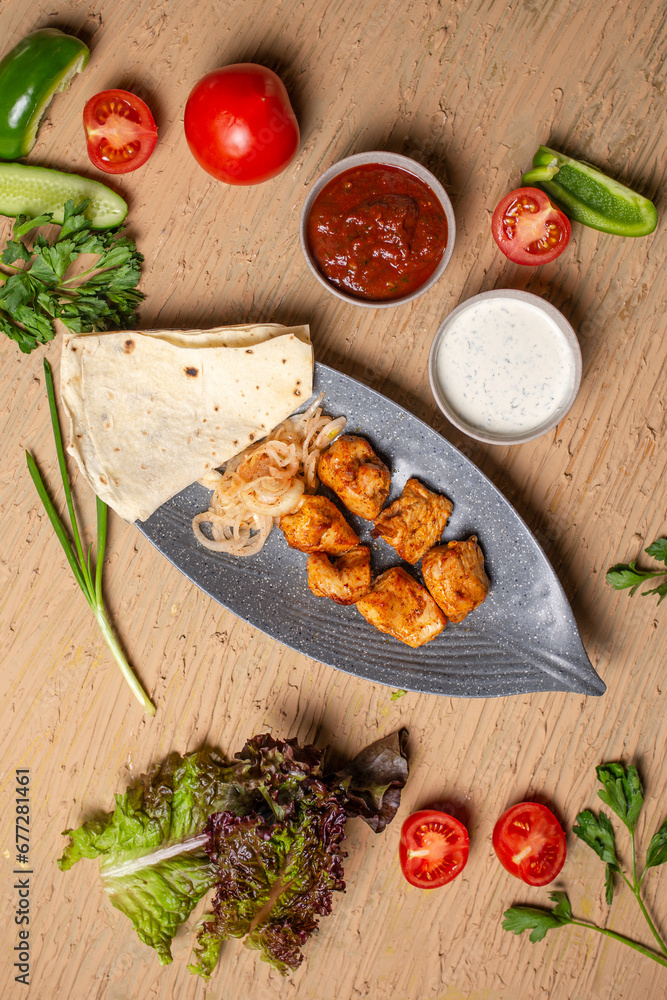 top view of a chicken kebab with sauce in a plate on a table in a restaurant top view of a chicken kebab with sauce in a plate on a table in a restaurant