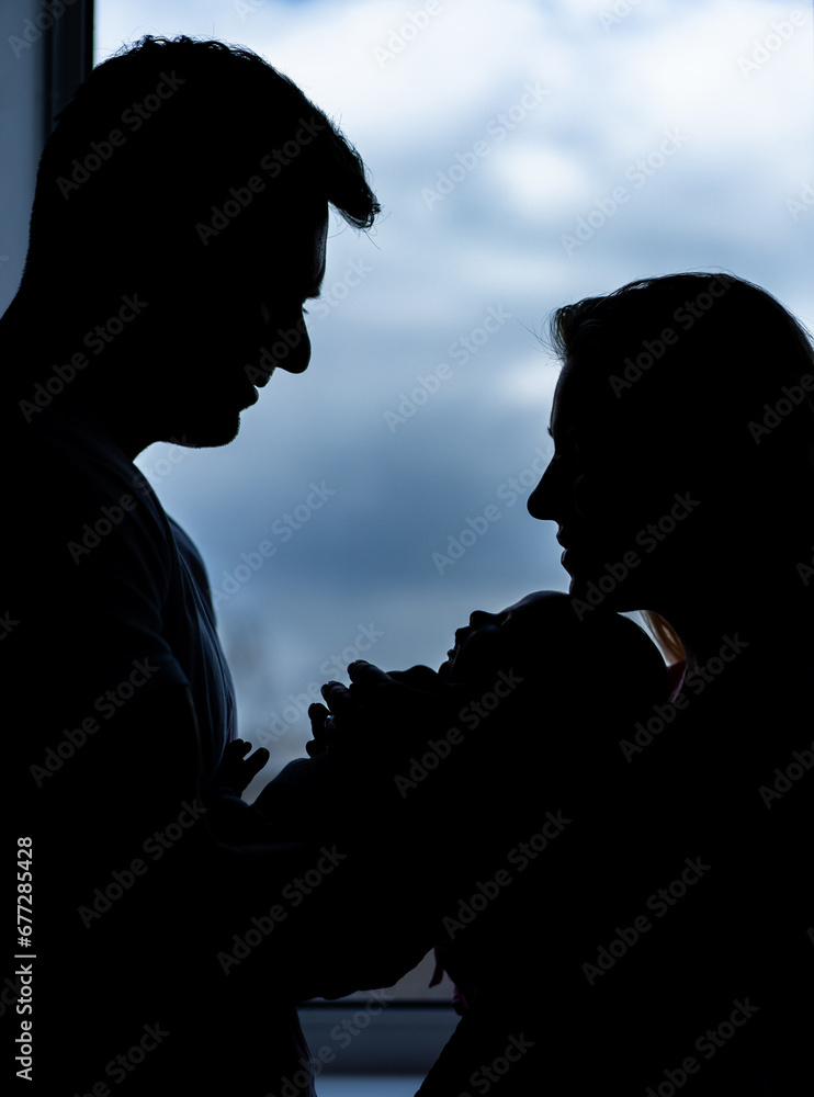 Shadow of happy couple with newborn baby. New family silhouette.