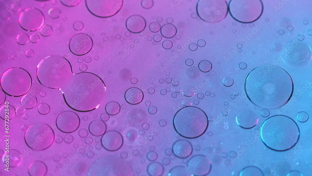 Abstract background. Oil water. Bubbles texture. Round stains spots floating on neon purple shimmering particles fluid surface in hypnotic art.
