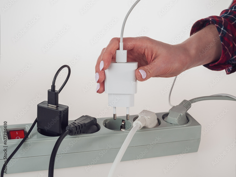 Various electrical plugs from electrical appliances connected to an extension cord isolated on a white background Various electrical plugs from electrical appliances connected to an extension cord isolated on a white background