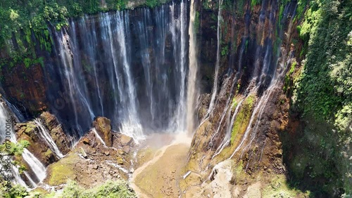 Aerial 4K footage of Tumpak Sewu also known as Coban Sewu waterfall and Semeru volcano mountain. A jungle waterfall in East Java,  Indonesia photo