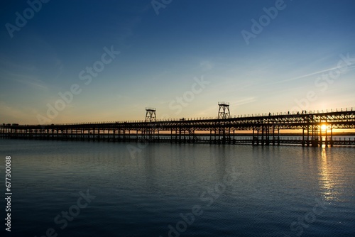 Rio Tinto pier in Huelva, Spain across the scenic Atlantic ocean against the sunset sky © Wirestock