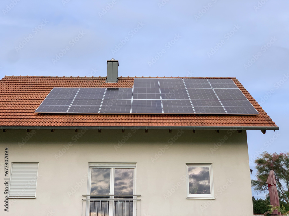 Solar photovoltaic panels on house roof. Modern country house with self-sustaining energy system Solar photovoltaic panels on house roof. Modern country house with self-sustaining energy system