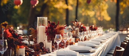 Autumn themed outdoor wedding with long white clothed banquet tables adorned with floral arrangements candles and tableware Copy space image Place for adding text or design photo