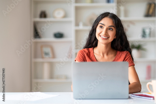 Happy Eastern Businesswoman Using Laptop At Home Office