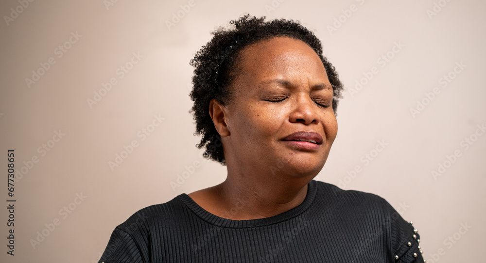 Black woman with eyes closed with sad expression on pastel background. - obrazy, fototapety, plakaty 