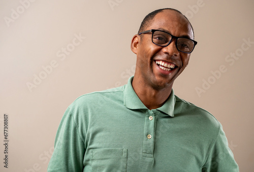 Man wearing glasses smiling on pastel background. © Brastock Images
