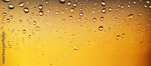 Close up macro shot of water drops on a golden background emphasizing condensation on a cold pint of beer Copy space image Place for adding text or design