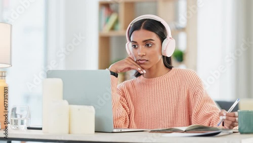 Student listening to online lesson, researching on laptop and listening to music in home living room. Woman wearing headphones for calming meditation song or binaural beats to help concentrate photo