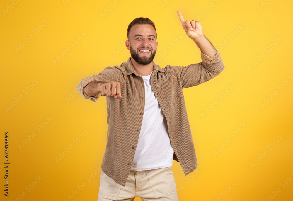 Positive young caucasian man with beard in casual point finger up and high five with fist gesture Positive young caucasian man with beard in casual point finger up and high five with fist gesture