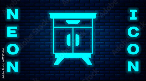Glowing neon Furniture nightstand icon isolated on brick wall background. Vector