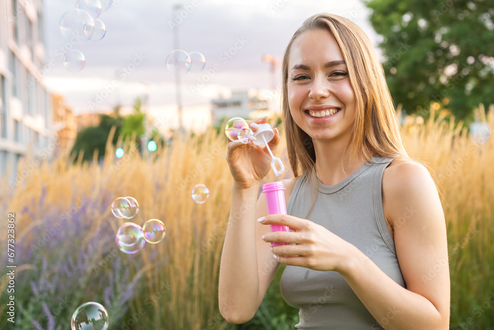 A joyous lady with long, flowing hair creates soap bubbles and smiles in the park. A joyous lady with long, flowing hair creates soap bubbles and smiles in the park.