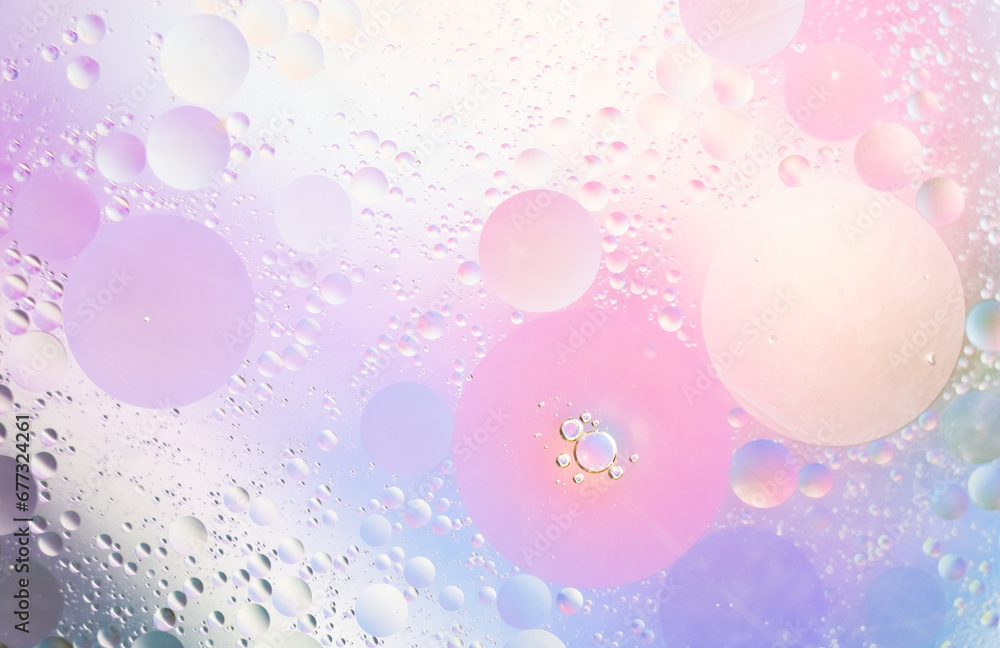 Abstract background in lilac and pink soft tones. Macro drops of oil on surface of the water. Delicate cosmetic background for advertising products. Abstract background in lilac and pink soft tones. Macro drops of oil on surface of the water. Delicate cosmetic background for advertising products.