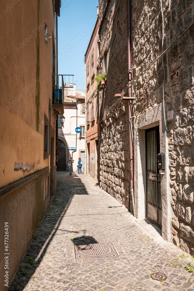 a cobbled street with traditional old houses in the medieval old town of Viterbo, Lazio, Italy 