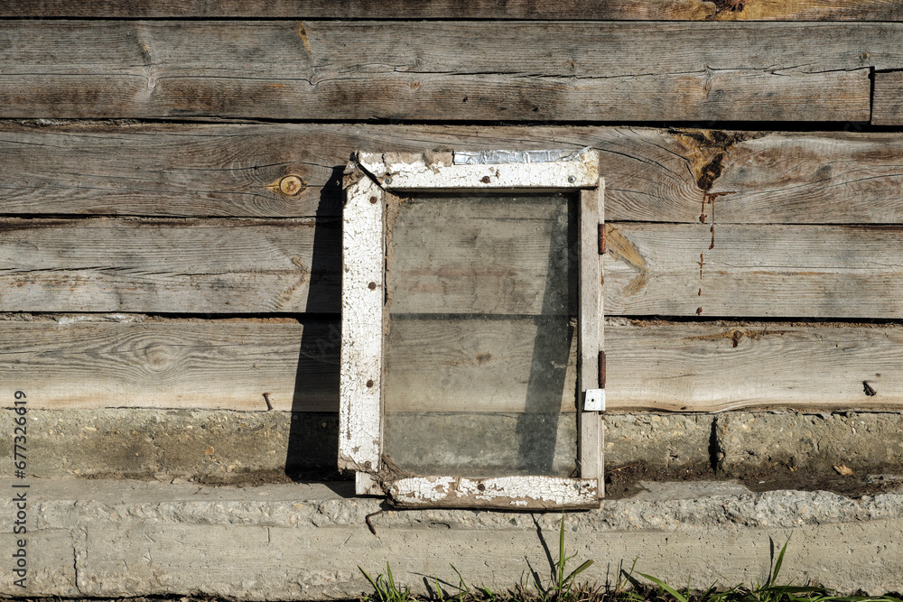 The white frame stands on the parapet, against the background of old boards.