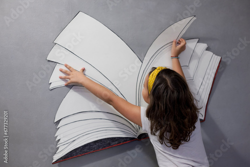 Libro e fantasia - bambina che legge libro immaginario photo