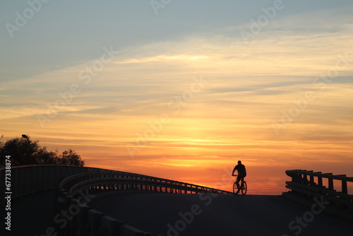 man on the bike in a sunset © Andrzej