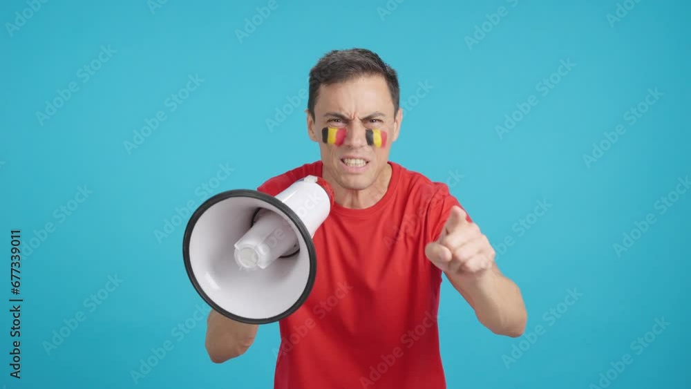 Excited man with belgian flag on face using a megaphone Excited man with belgian flag on face using a megaphone