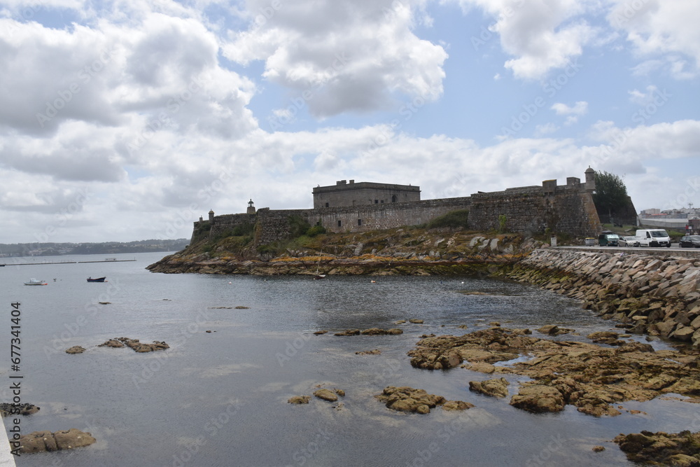 views of the castle of san anton in la coruña, spain. Blue sky with clouds and part of the sea and pier. nature.