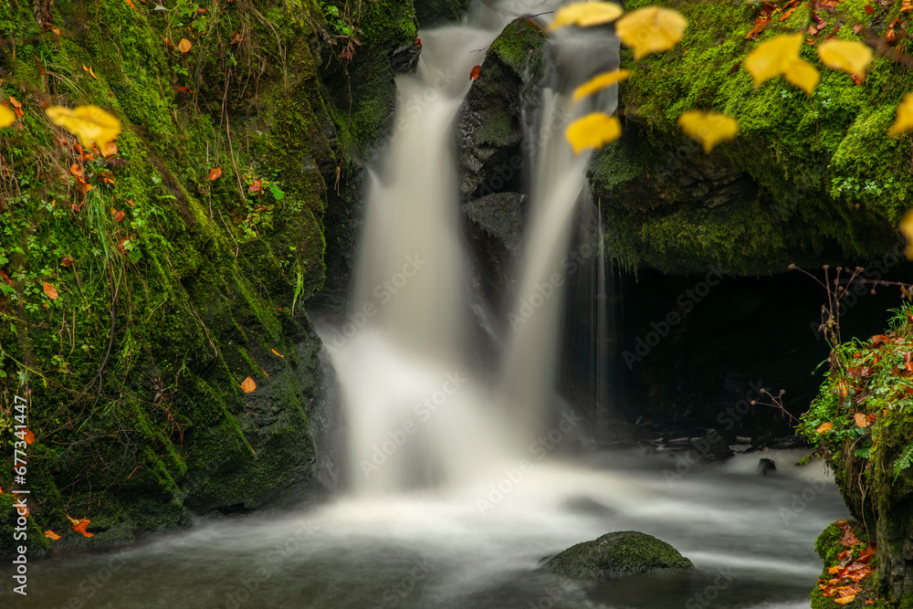 Naklejka premium Doubrava river with color rock with moss in autumn day near Bilek village
