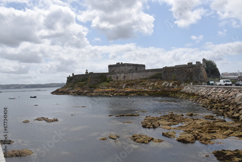 views of the castle of san anton in la coru  a  spain. Blue sky with clouds and part of the sea and pier. nature.