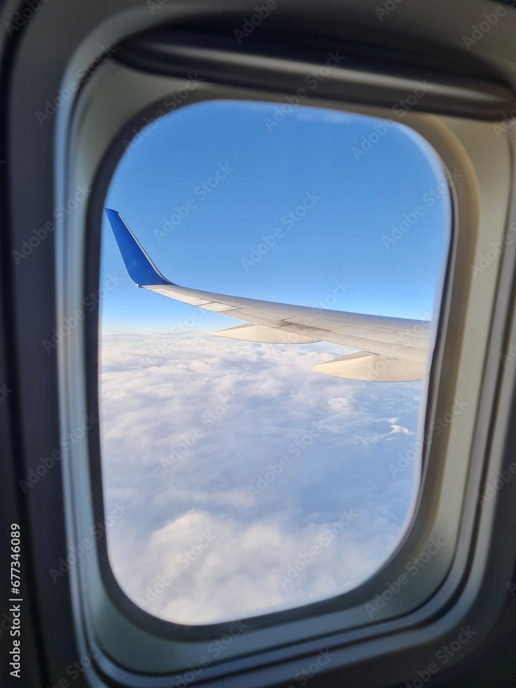 Nice sky view from the airplane's window with an airplane's wing, blue sky view with, sea of mist Nice sky view from the airplane's window with an airplane's wing, blue sky view with, sea of mist