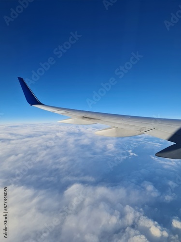 Nice sky view from the airplane's window with an airplane's wing, blue sky view with, sea of mist 