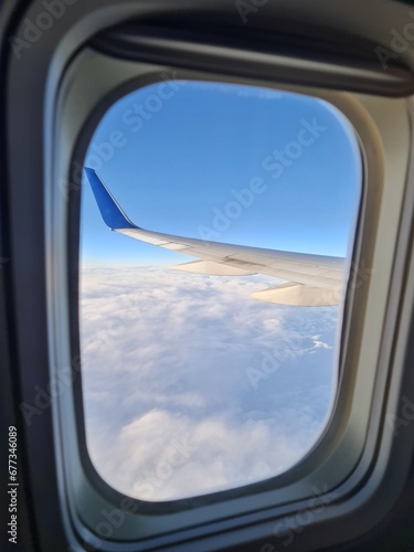 Nice sky view from the airplane's window with an airplane's wing, blue sky view with, sea of mist